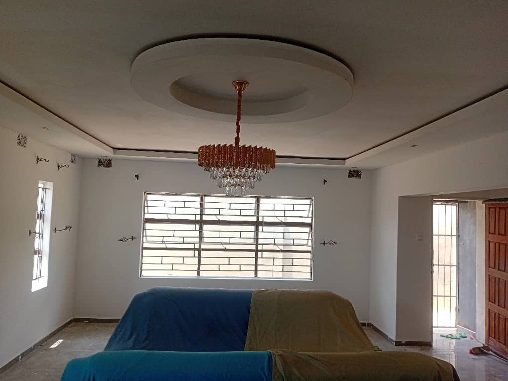 A living room with a Fabish rhinoboard ceiling, cornices and chandelier